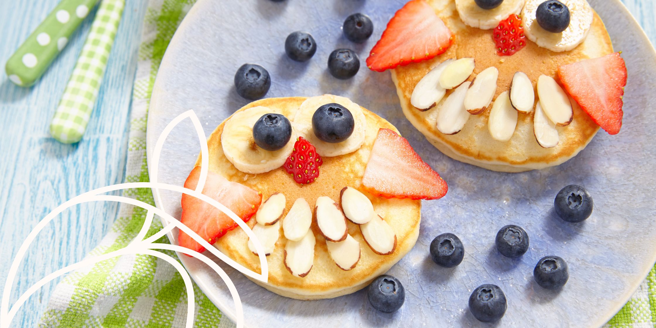 Pancakes turned into little owls with blueberries, bananas, strawberries and slivered almonds.