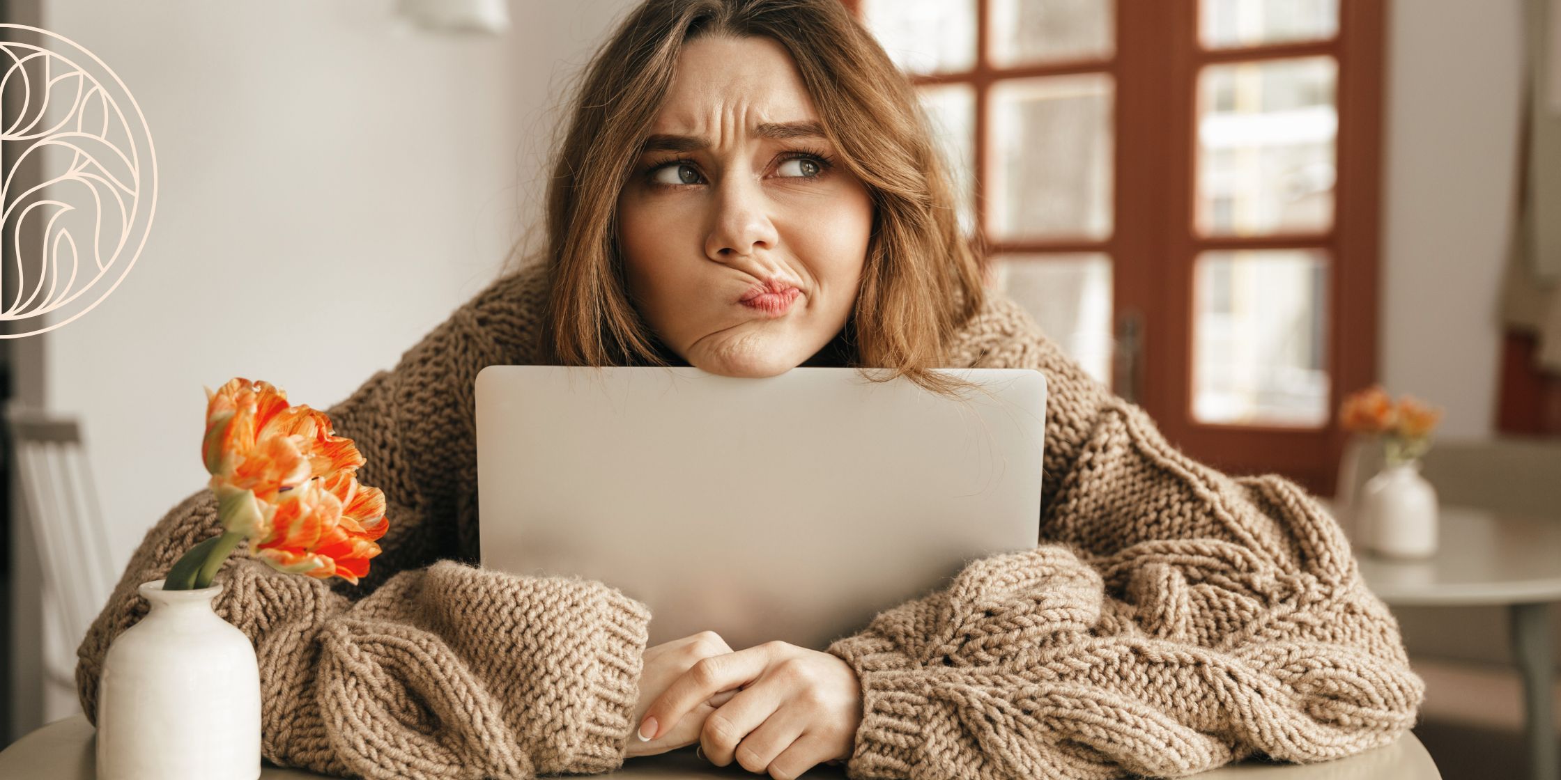 A woman sitting at a table with her laptop, arms wrapped around the screen and chin resting on top. She wears an oversized brown cable-knit sweater and has a confused, thoughtful expression, as if trying to remember something important.