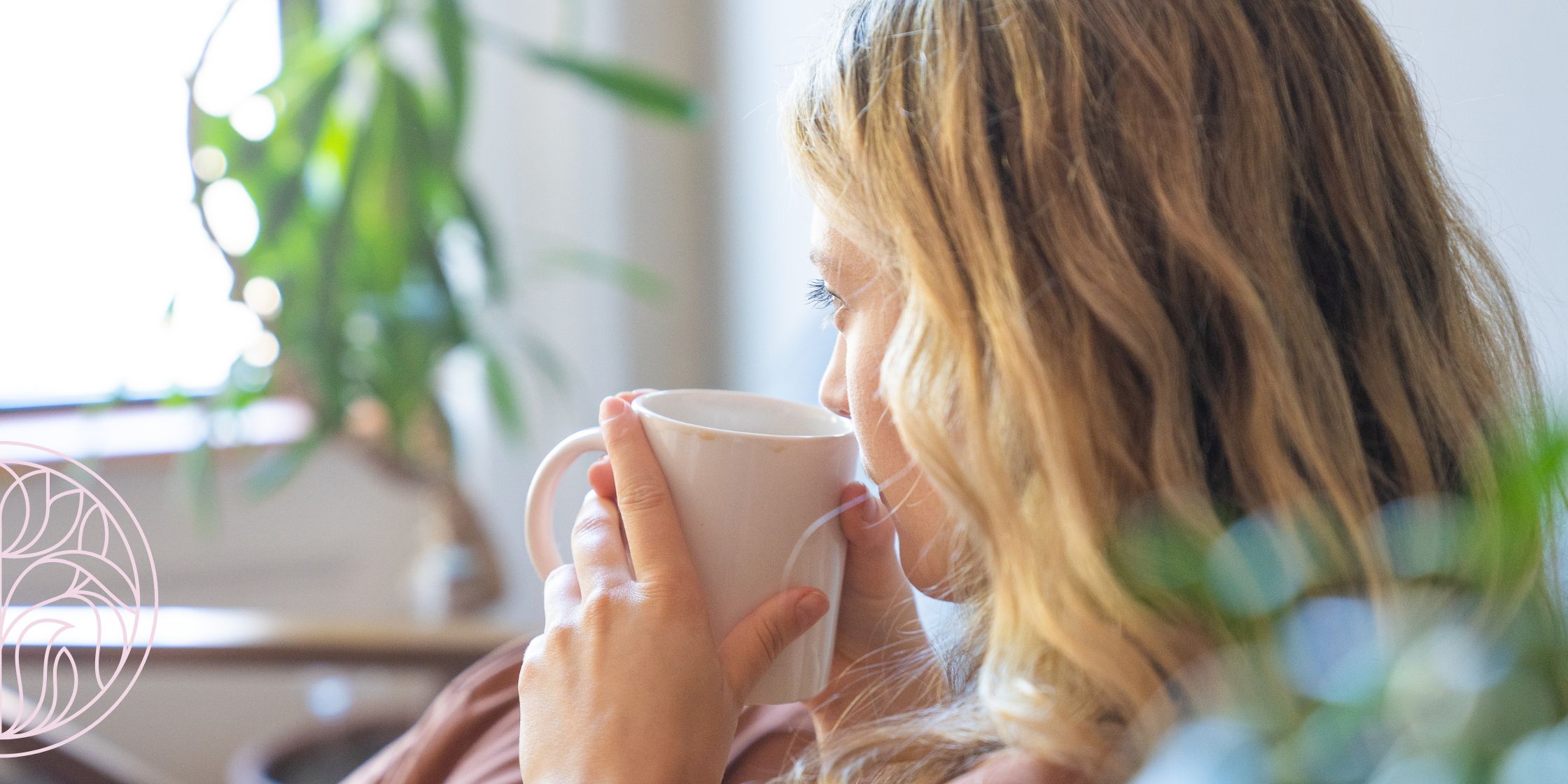 A peaceful image of a woman sitting quietly with a warm drink in hand, sunlight streaming in—capturing a real-life moment of simple, meaningful self-care.
